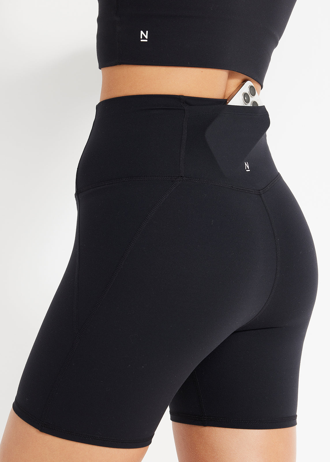 Side view of black bike shorts with phone pocket and flattering seam lines