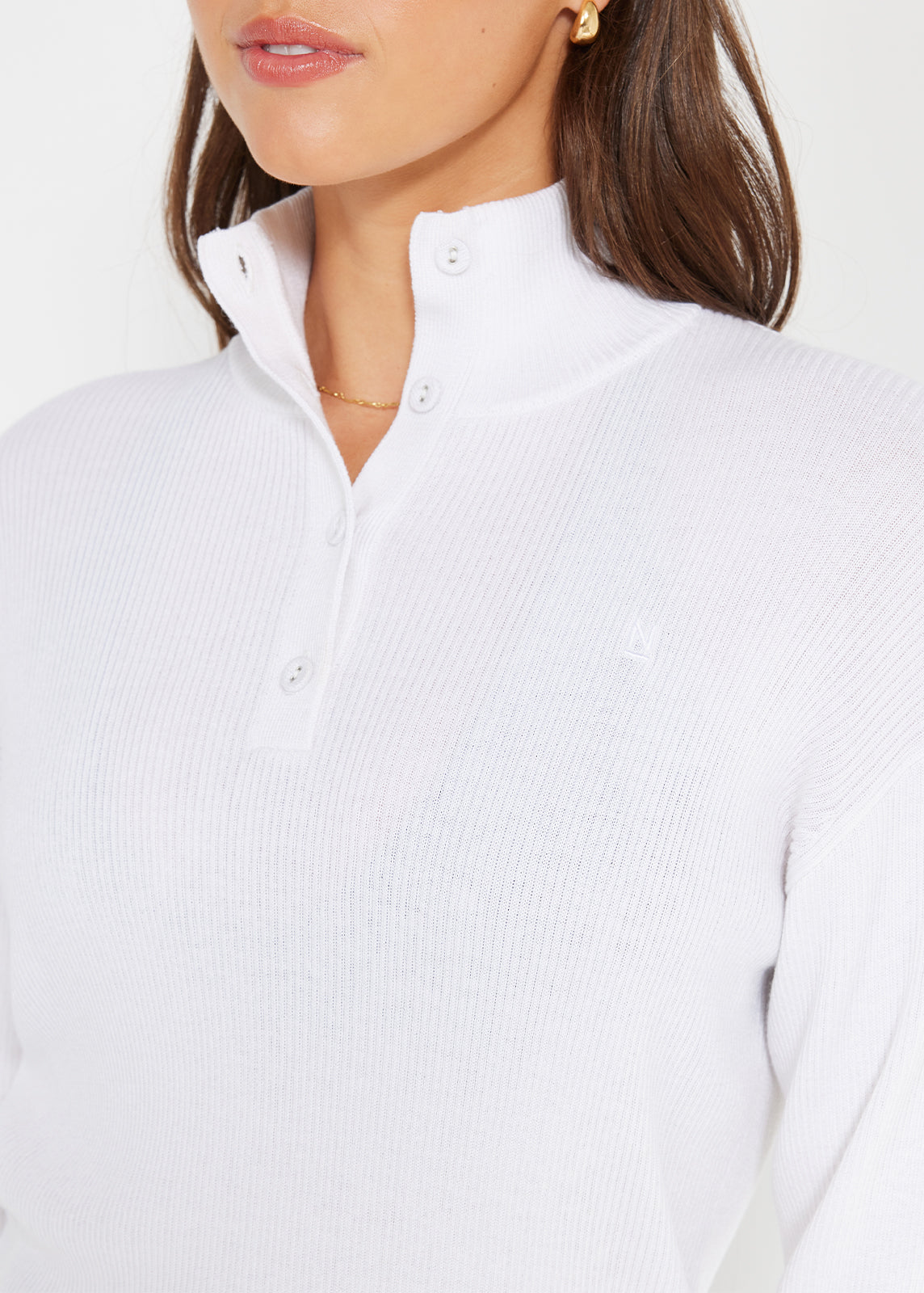 Close-up of white ribbed henley jumper with button-up collar detail