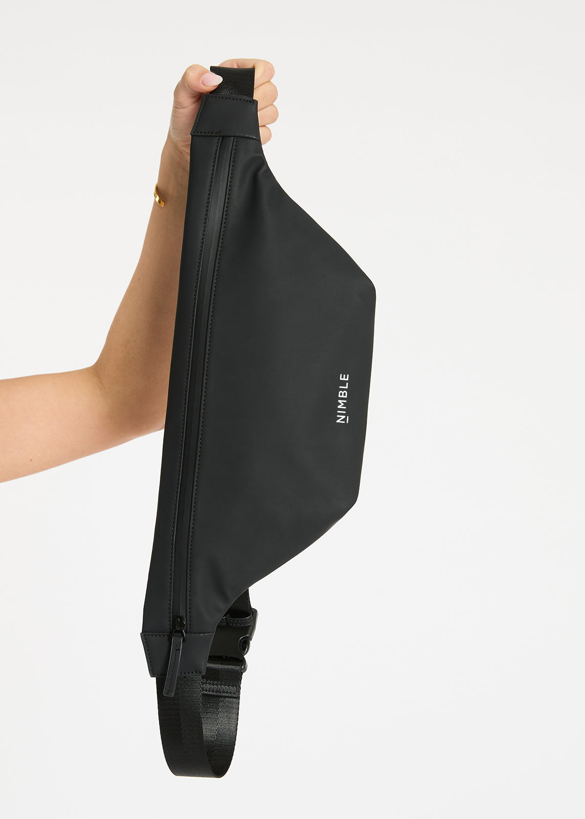 Model Holding A Black Splash Proof Cross Body Bag With Contrasting White Nimble Logo To The Centre Bottom.