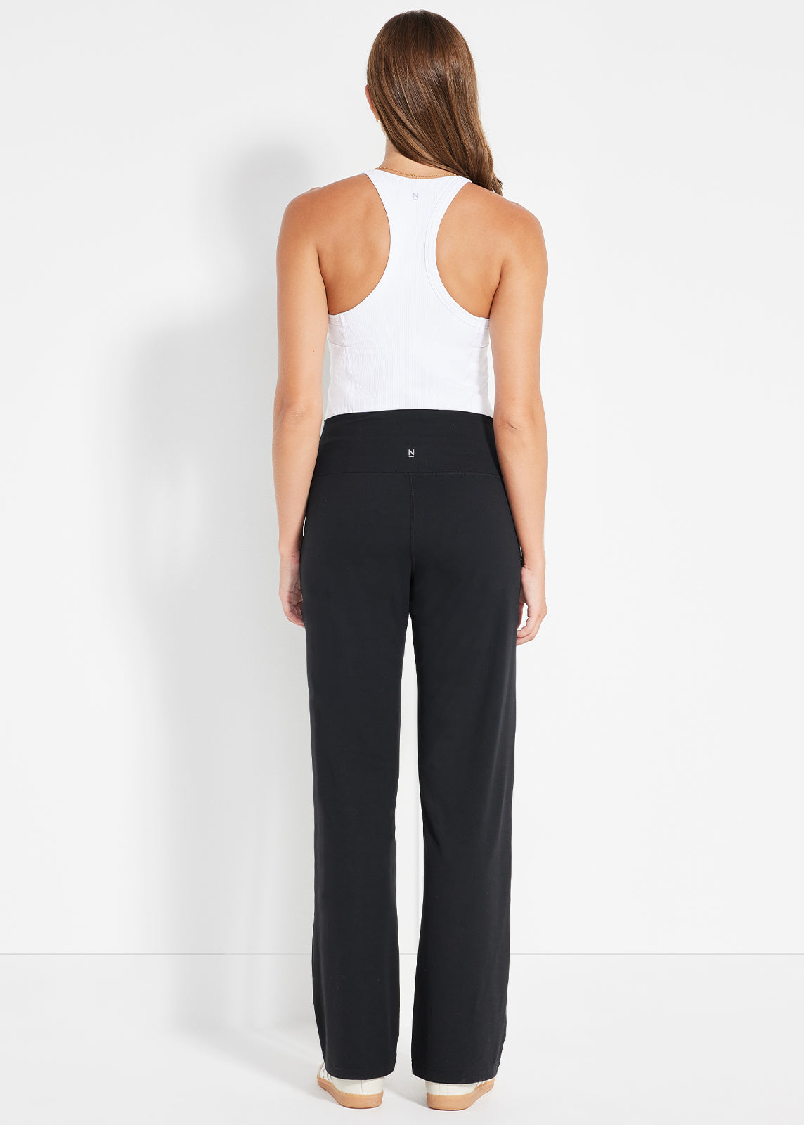 Product image showing model wearing black wide-leg pants and white racerback tank from back view