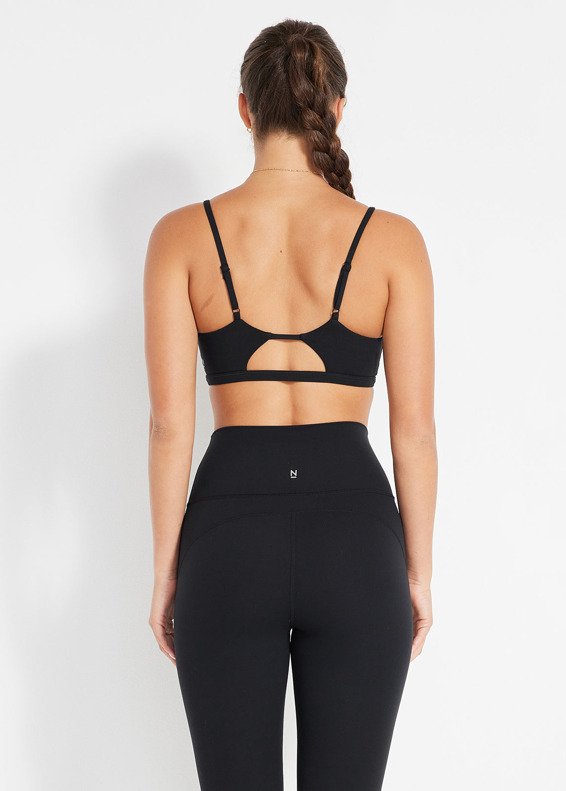 Back view of black strappy bralette and high-rise leggings with keyhole detail