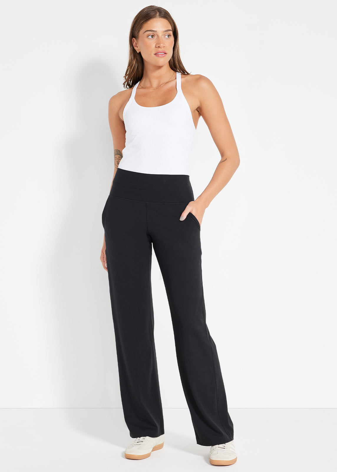 Product image of model wearing white tank top and black wide-leg pants with hands in pockets