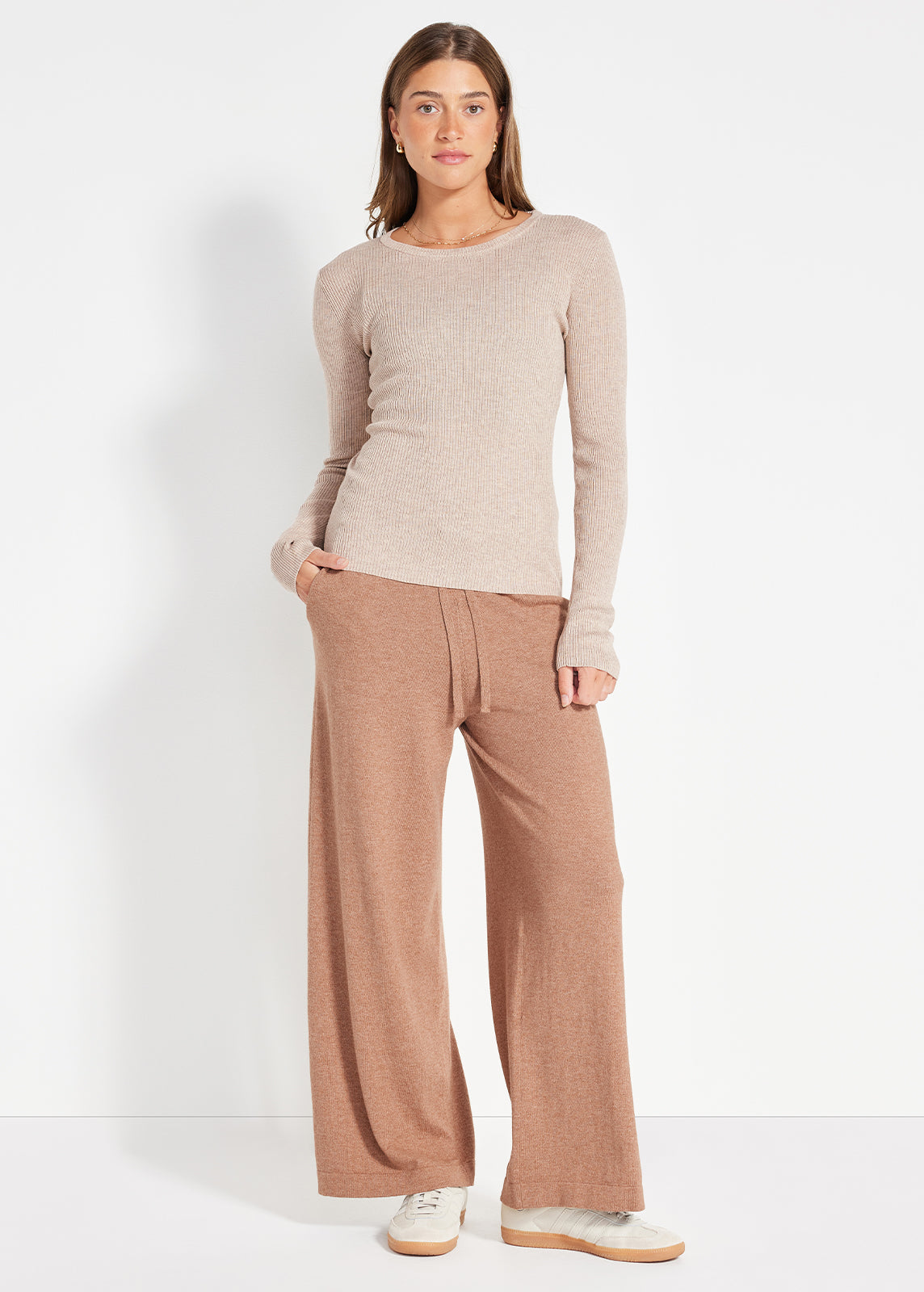 Model wearing beige ribbed knit top paired with camel wide-leg lounge pants and sneakers