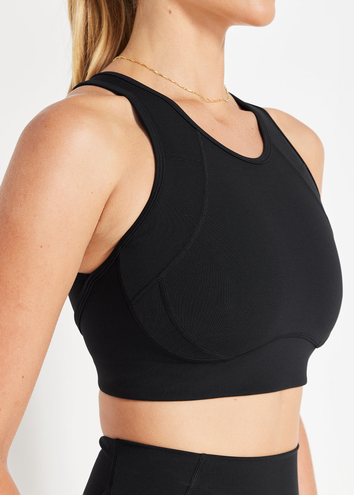 Close-up of model wearing black supportive sports bra with racer neckline