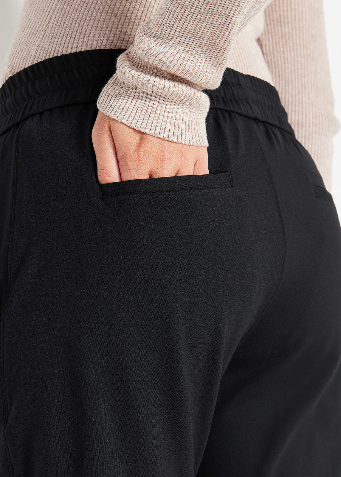 Close-up of back pocket detail on black jogger pants made from recycled fabric with a soft, flexible fit