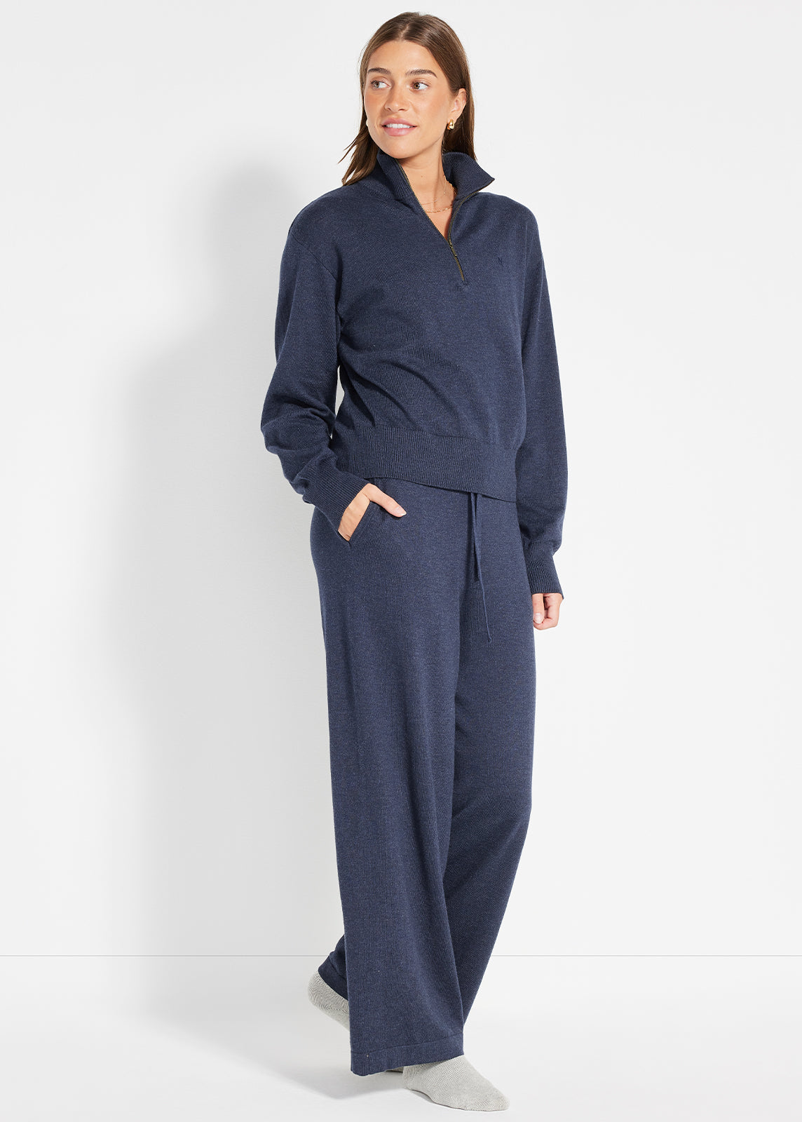 Model wearing navy knit half-zip jumper and matching drawstring pants with relaxed fit