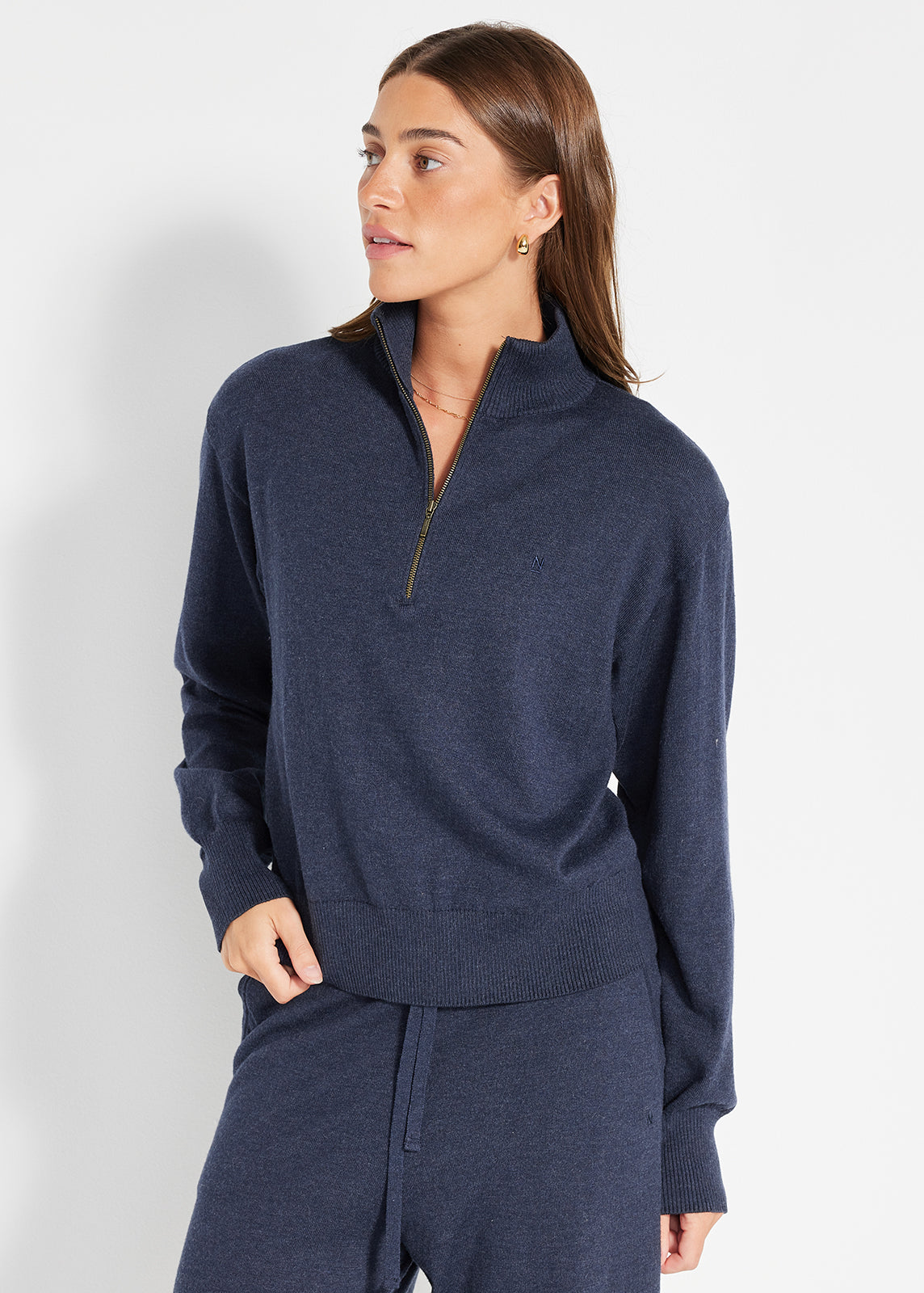 Model wearing navy half-zip knit jumper paired with matching lounge pants