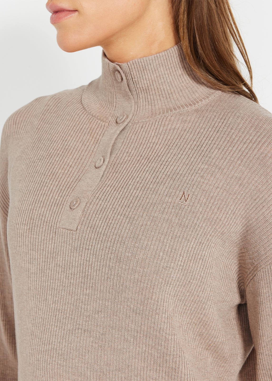 Close-up of beige ribbed henley jumper with button-up neckline and embroidered logo
