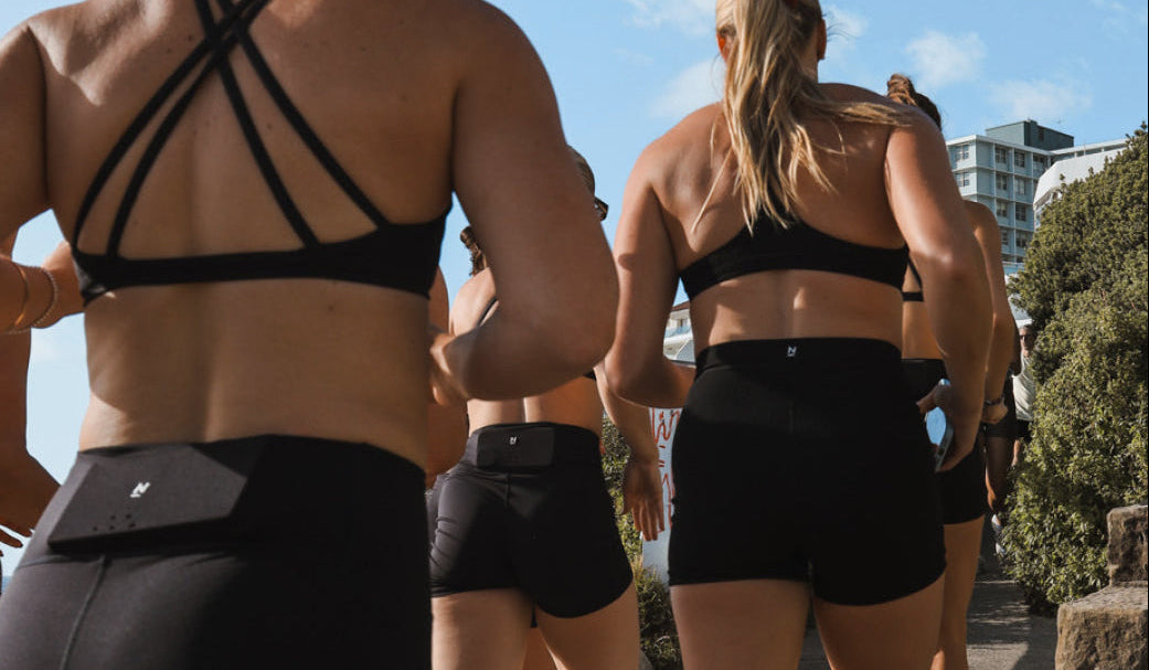 Group of women running in shorts and crop tops