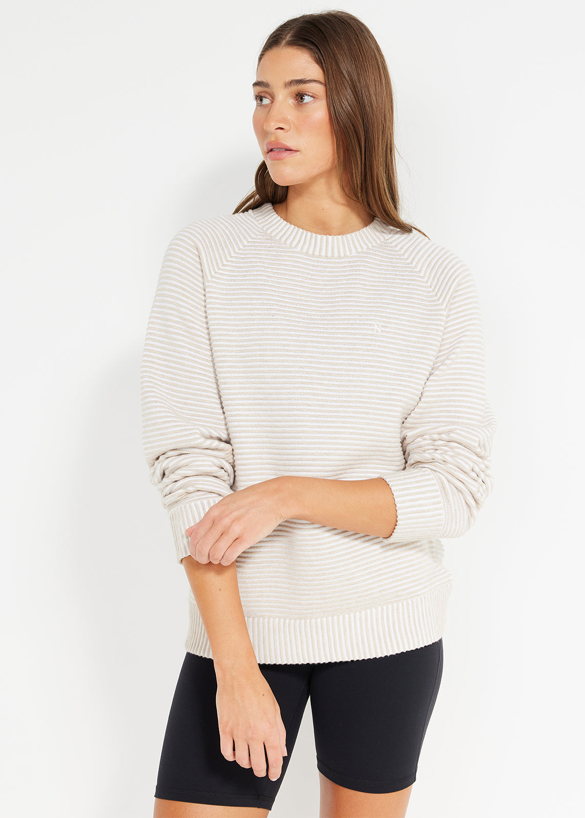 Model wearing beige striped knit jumper with long sleeves and relaxed fit