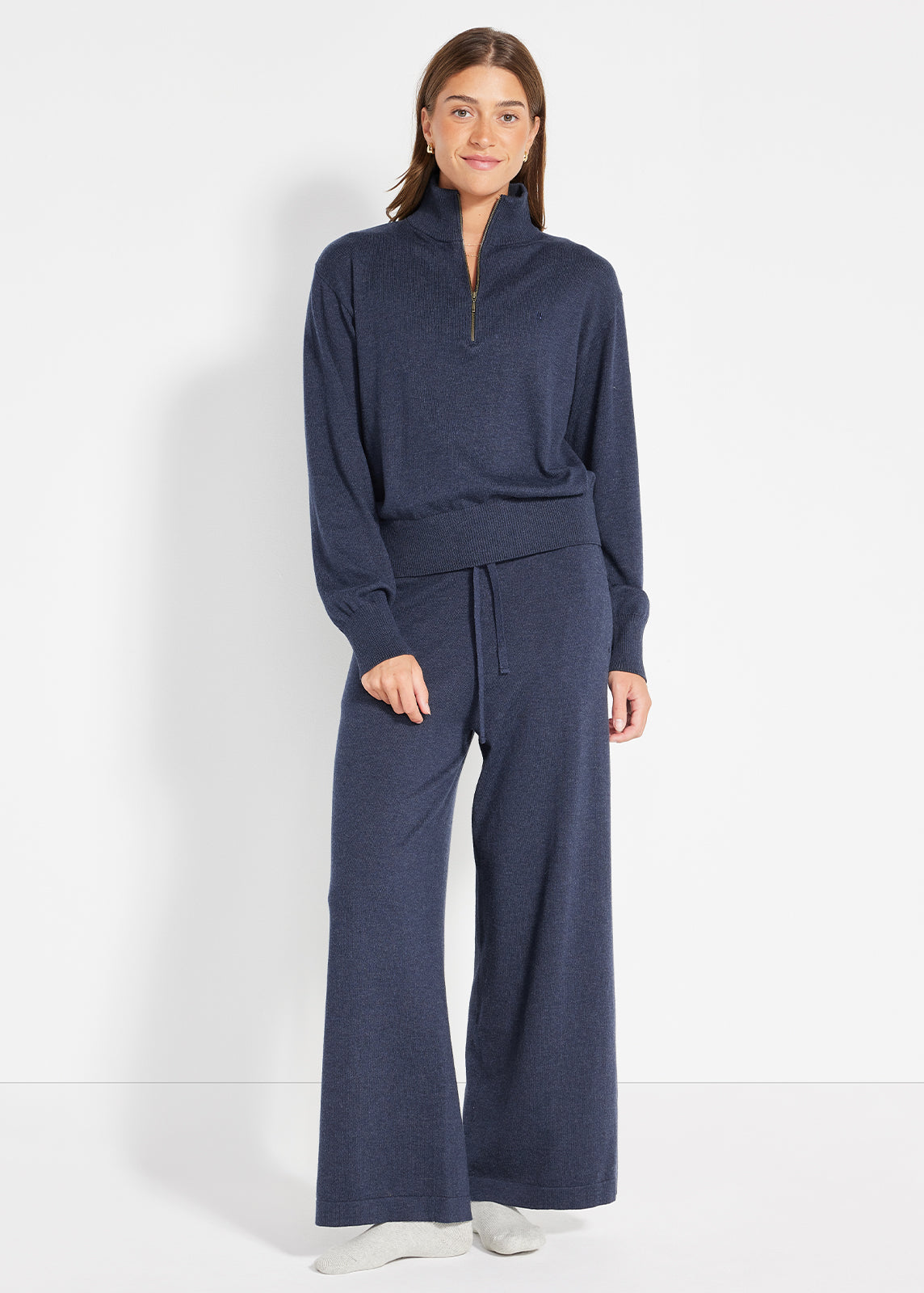 Model wearing navy knit half-zip jumper with matching drawstring wide-leg pants