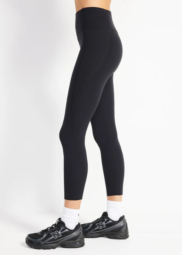In Motion Pocket 7/8 Legging in black, shown from the side with a high-rise waistband and side pocket.