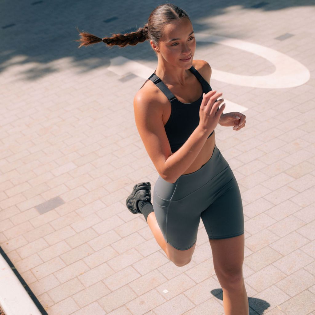 Runner sprinting uphill in Nimble In Pace activewear.